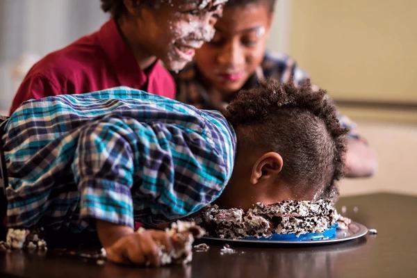 afro-boys-face-smashing-cake-600nw-391124992.webp.jpg